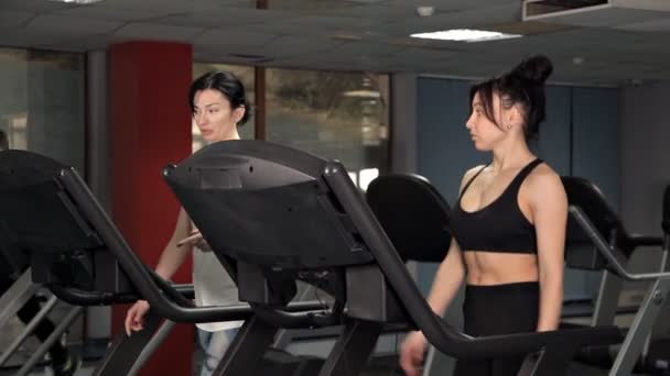 Mulheres jovens é adequado para fazer exercícios de corrida no ginásio na esteira . — Vídeo de Stock