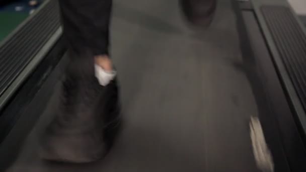 Close-up van Foot Sneakers fitness draait op loopband, gespierde benen in Gym — Stockvideo