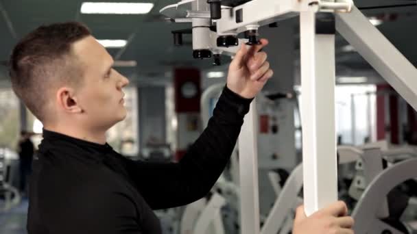 La main des hommes réduit le poids sur le simulateur, sélectionnez la broche Changer la pile de poids de la plaque. . — Video