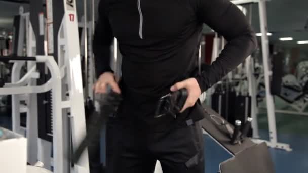 Hombre sujetando su cinturón de protección para levantar pesas pesadas en el gimnasio — Vídeo de stock