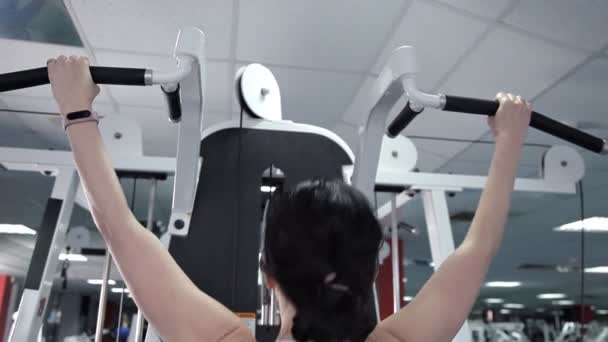 Sportieve vrouw doet oefeningen de spieren van de achterkant van de handen gewichten in de sportschool. De Turnstile, het meisje trainen op de loopband in het fitnesscentrum — Stockvideo