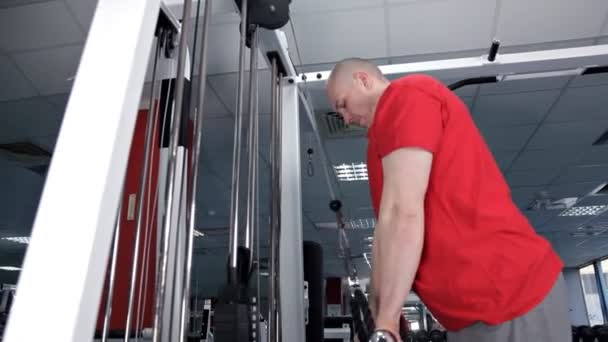 Un homme dans la salle de gym secoue ses triceps — Video