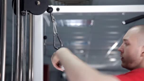 Ein Mann im Fitnessstudio schüttelt seinen Trizeps — Stockvideo