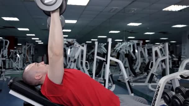 Man liggend op bankdrukken tijdens het sporten met Dumbbell — Stockvideo