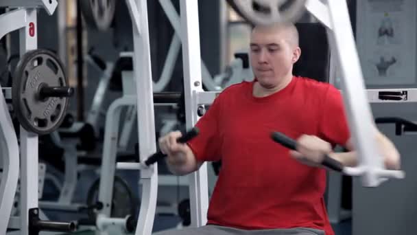 Un joven flexionando los músculos del pecho en el simulador. Salud, deporte — Vídeo de stock