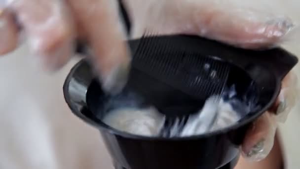 Ein Friseur mischt Haarfärbemittel in einer Schüssel, bereitet die Farbe für die Haare vor — Stockvideo
