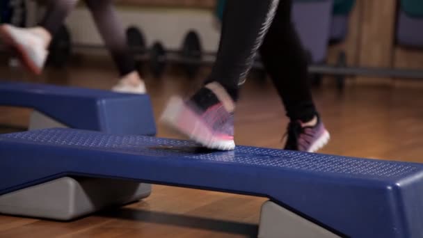 Allenatrice atletica che fa lezione di aerobica con i steppers al gruppo della gente su un centro fitness. Sport e salute — Video Stock