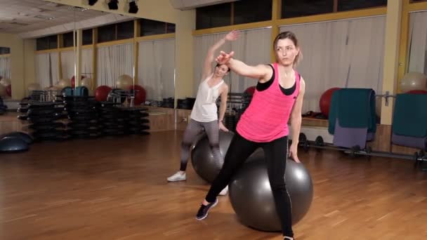 Mujer joven haciendo ejercicio con pelota suiza.Clase de pelota de fitness — Vídeos de Stock