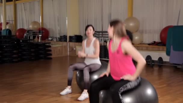 Mujer joven haciendo ejercicio con pelota suiza.Clase de pelota de fitness — Vídeos de Stock