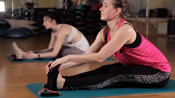 Jonge meisjes doen oefeningen op de mat voor yoga. Het concept van een gezonde levensstijl en sport. Oefenreeks — Stockvideo