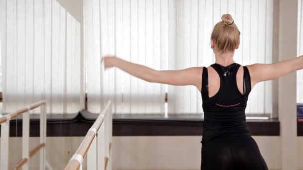 Schöne Turnerin macht den Spagat in einem Raum mit Ballettdrehbank und Spiegel — Stockvideo