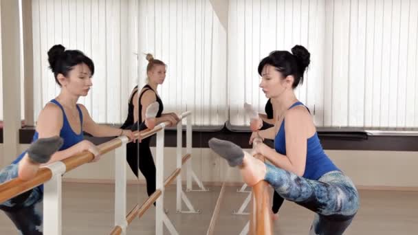 Schöne junge Frauen beim Spagat im Proberaum. schlanke Mädchen stehen vor dem Spiegel und trainieren — Stockvideo