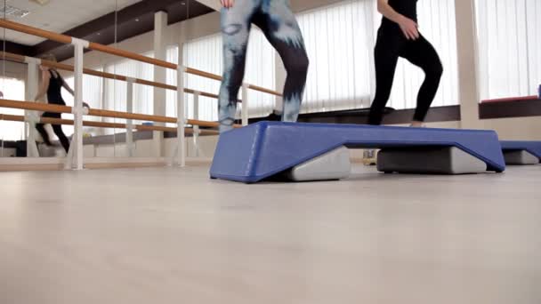 Schritt-Plattformen. Fuß auf der Trittplattform. Unterricht in der Turnhalle. Fitness-Aerobic — Stockvideo