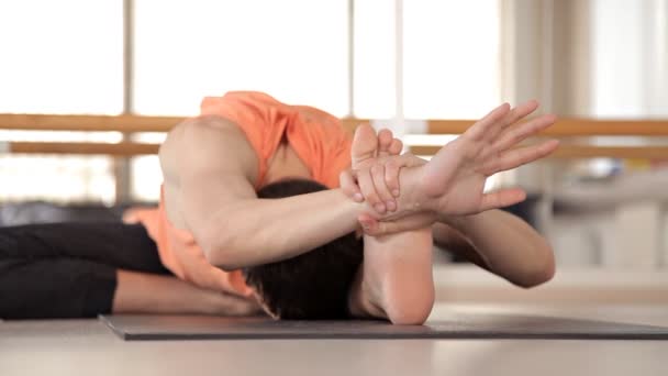 Een persoon die geavanceerde yoga beoefenen. Een sterke man die yoga oefeningen uitvoert in de Studio — Stockvideo