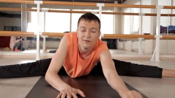 Uomo che pratica yoga nella ginna.Uomo che fa asana yoga alla luce dello Studio. Luminoso studio con grandi finestre e specchi — Video Stock