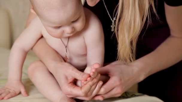 Massage für das kleine Baby, das das Baby vom Massagetherapeuten im Massageraum mit Öl auf dem Bett durchführt. Manuelle Therapie für Kinder. Mutterschaft. — Stockvideo