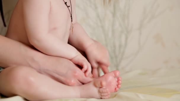 Массаж для малыша ребенок делает массажист в массажной комнате с маслом на кровати. Ручная терапия для детей. материнство . — стоковое видео