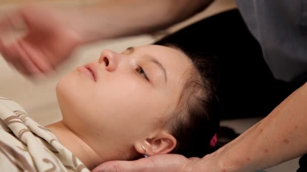 Close-up van een klein meisje tijdens een osteopathische therapiesessie. De therapeut manipuleert het hoofd van de Childs. Massage in de Spa — Stockvideo