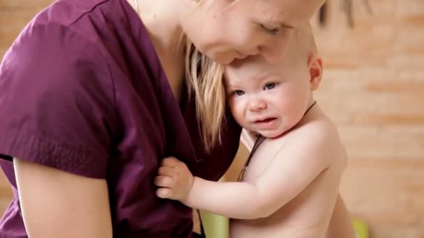 Pediatra, masajista sosteniendo a un bebé que está llorando. Salud infantil — Vídeo de stock