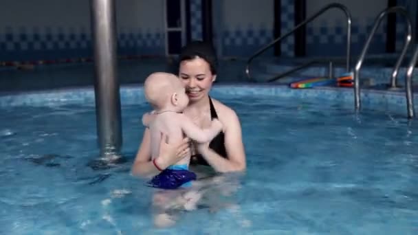 Famiglia sana, la madre insegna al bambino a nuotare in piscina. Salute dei bambini — Video Stock