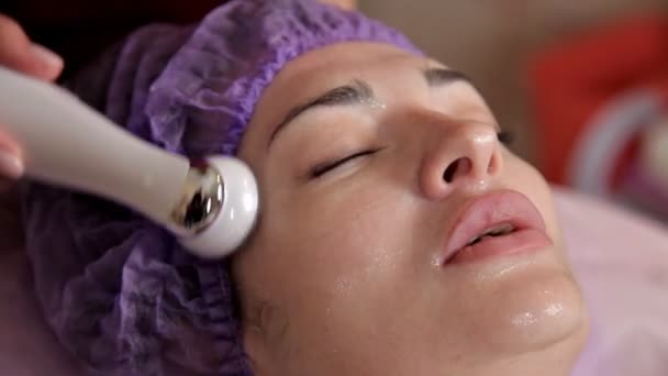 Female face, collagen mask. Machine for skin tightening. Aesthetic medicine. Laser skin discoloration. Woman during laser facial surgery — Stock Video