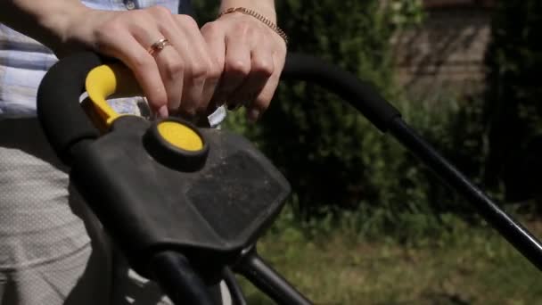 Female hands include electric lawn mower. close up — Stock Video