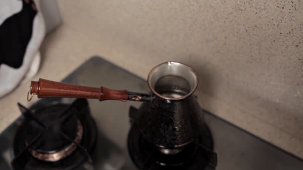 La tradizione del caffè mattutino. dipendenza da caffeina. forte bevanda calda, appena preparata in una jezve o in una pentola turca nelle mani di una donna — Video Stock