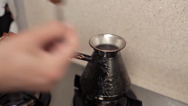 Жінка варить каву рано вранці на кухні на газову плиту. Турецька кава, смачний аромат — стокове відео