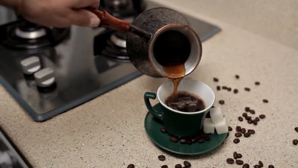Жінка вливає гарячу ароматичну каву в чашку за столом, крупним планом. Лінивий ранок — стокове відео