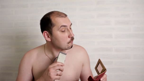 En man rakar en stor skägg med en rakapparat. närbild porträtt av en person — Stockvideo
