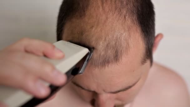 Homem careca a rapar o cabelo com uma lâmina eléctrica na casa de banho. Cuidados de beleza, beleza — Vídeo de Stock