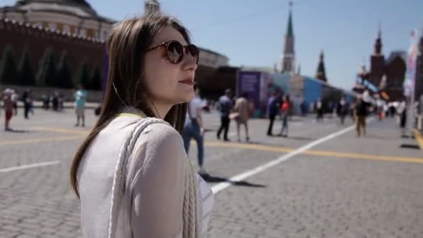 Uma menina caminha e admira a Praça Vermelha e o Kremlin em Moscou. Excursão — Vídeo de Stock