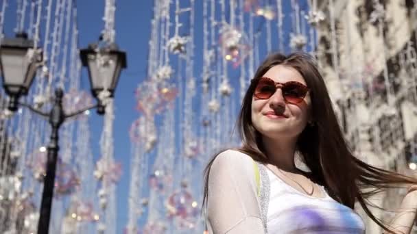 A rapariga no fundo das luzes da rua no fio. Lâmpadas-lâmpadas pendurar decorações contra o céu azul no verão — Vídeo de Stock