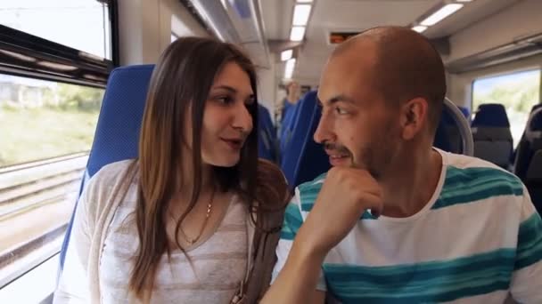 Viajando de una elegante pareja joven viajando juntos en un vagón de ferrocarril hablando entre sí. Transporte rápido, tren — Vídeos de Stock