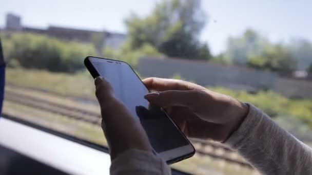 Крупним планом руки молодої леді, використовуючи смартфон в поїзді — стокове відео
