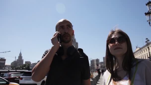 У мегаполісі чоловік викликає дівчину таксі, використовуючи функцію голосу на смартфоні. Допомога новоприбулої дівчини з великим містом — стокове відео