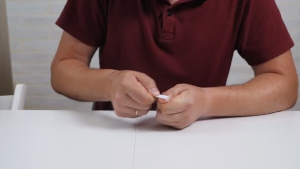 Um careca senta-se à mesa e cuida das unhas. Ficha de unhas — Vídeo de Stock