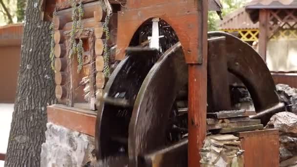 Ein hölzernes Rad erzeugt Energie mit der Kraft des Wassers, einem alten traditionellen Mechanismus. Holzring dreht sich mit der Kraft des Wassers — Stockvideo