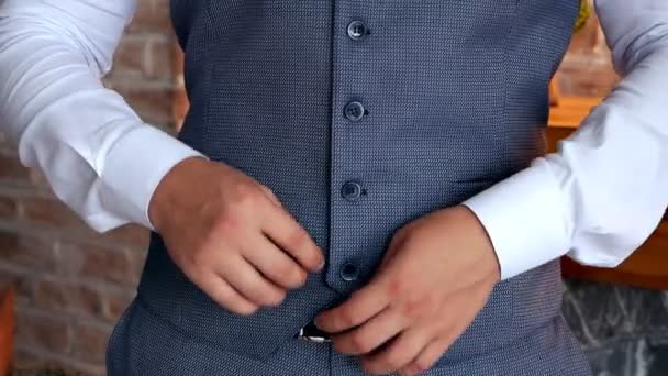 Un jeune homme réussi attache des boutons sur une veste un jour de mariage. Préparation du mariage Célébration — Video