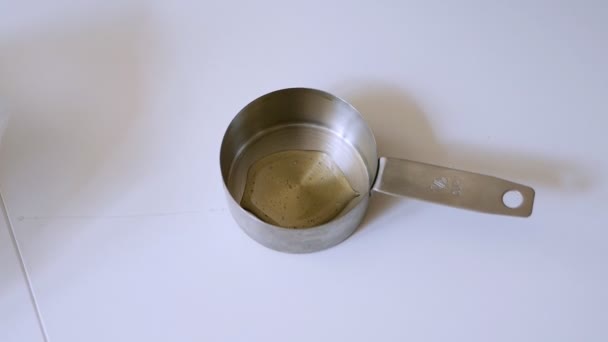 Dziewczyna wylewa miód do mini patelni w kuchni — Wideo stockowe