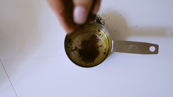 Meisje hagelslag honing met specerijen in een mini pan — Stockvideo