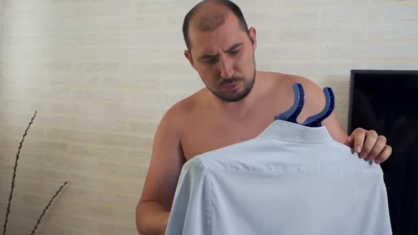 Лисий чоловік використовує парову систему для прасування одягу, парова сорочка вдома — стокове відео