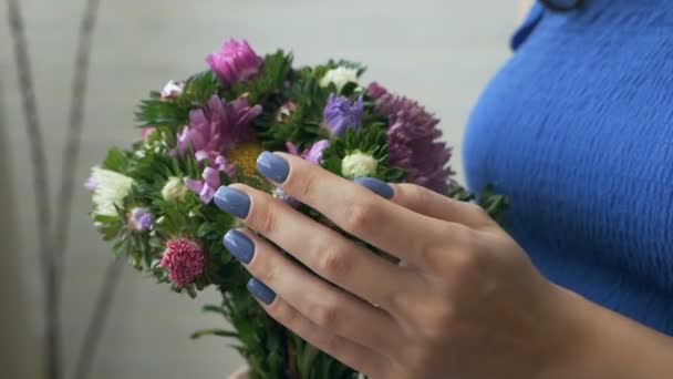 Молодая беременная женщина, нюхающая цветок, трогающая живот — стоковое видео