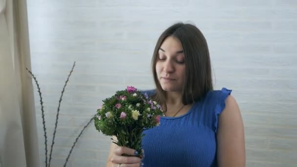 A young pregnant woman sniffs a flower and is allergic — Stock Video