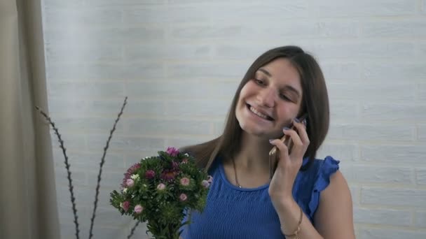 Una giovane donna ha trovato un mazzo di fiori a casa. Felice ragazza eccitata chiama un ragazzo — Video Stock