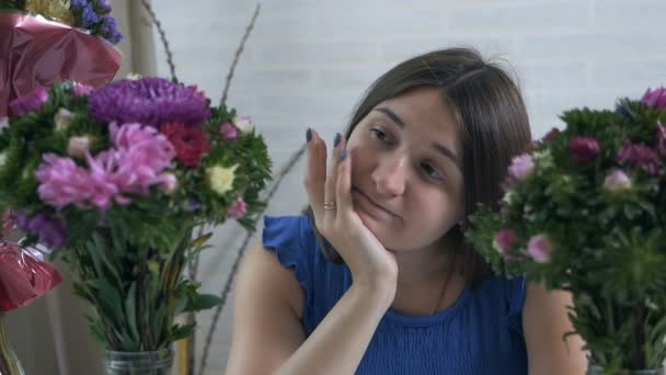 Närbild profil porträtt av en vacker och ung kvinna njuter och luktar en bukett blommor — Stockvideo