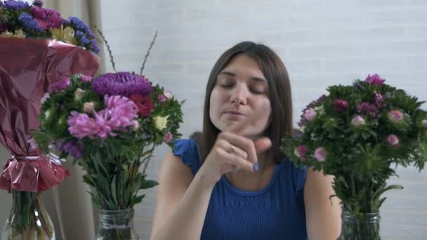 花の花束を楽しみ、匂いを嗅ぐ美しい若い女性のクローズアッププロフィールの肖像画 — ストック動画