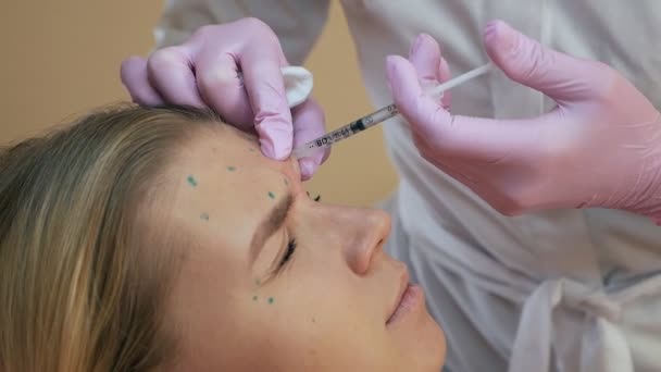 Schönheitsklinik. Kosmetikerin Hände mit Handschuhen machen Gesicht Alterung Injektionen in weibliche Haut. Frau bekommt kosmetische Gesichtsbehandlungen. Botox-Kollageninjektionen — Stockvideo