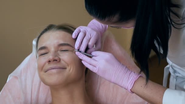 Mujer hermosa recibiendo inyección cosmética en el área de los ojos de esteticista. concepto de belleza limpia — Vídeos de Stock