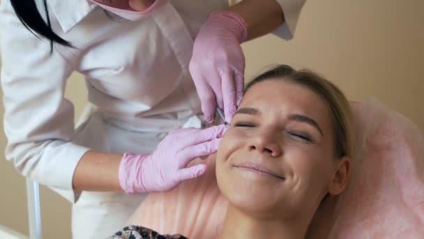 Mooie vrouw krijgen van cosmetische injectie in oogcontour van schoonheidsspecialiste. Schone Beauty concept — Stockvideo